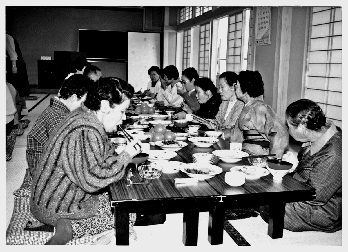 座卓を囲んで食事をする高齢の人たち